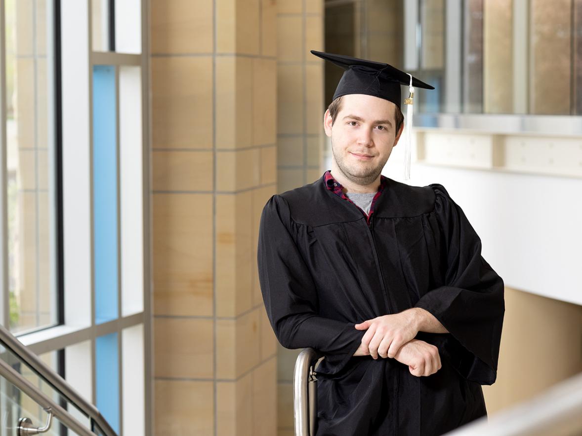 Jose Estrada, game design and development-art inspiring graduate in the grand stairwell at Memorial Student Center.