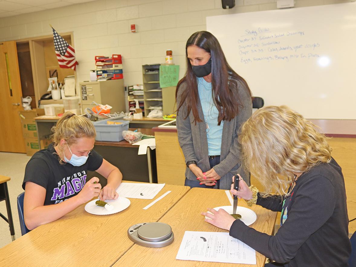 Kelley, in center, with students working on a pickle autopsy, which is part of a health class that gives students technical college credit.