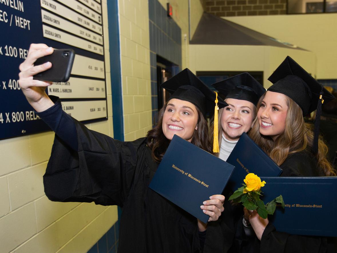 Graduates with their diplomas take a selfie after the fall 2019 commencement at UW-Stout.