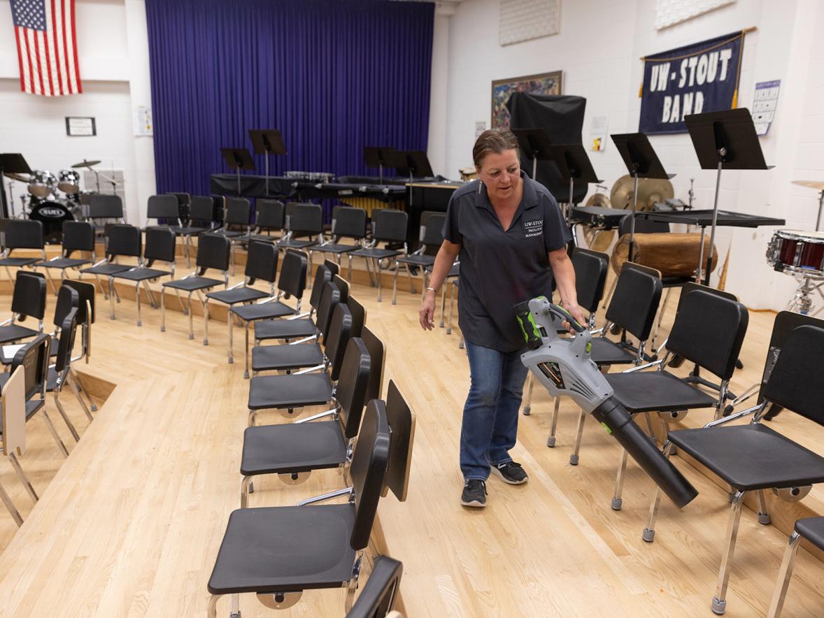 Sara Moltzan, a member of the UW-Stout academic custodial staff, uses a leaf blower while cleaning the band room in the Applied Arts Building.