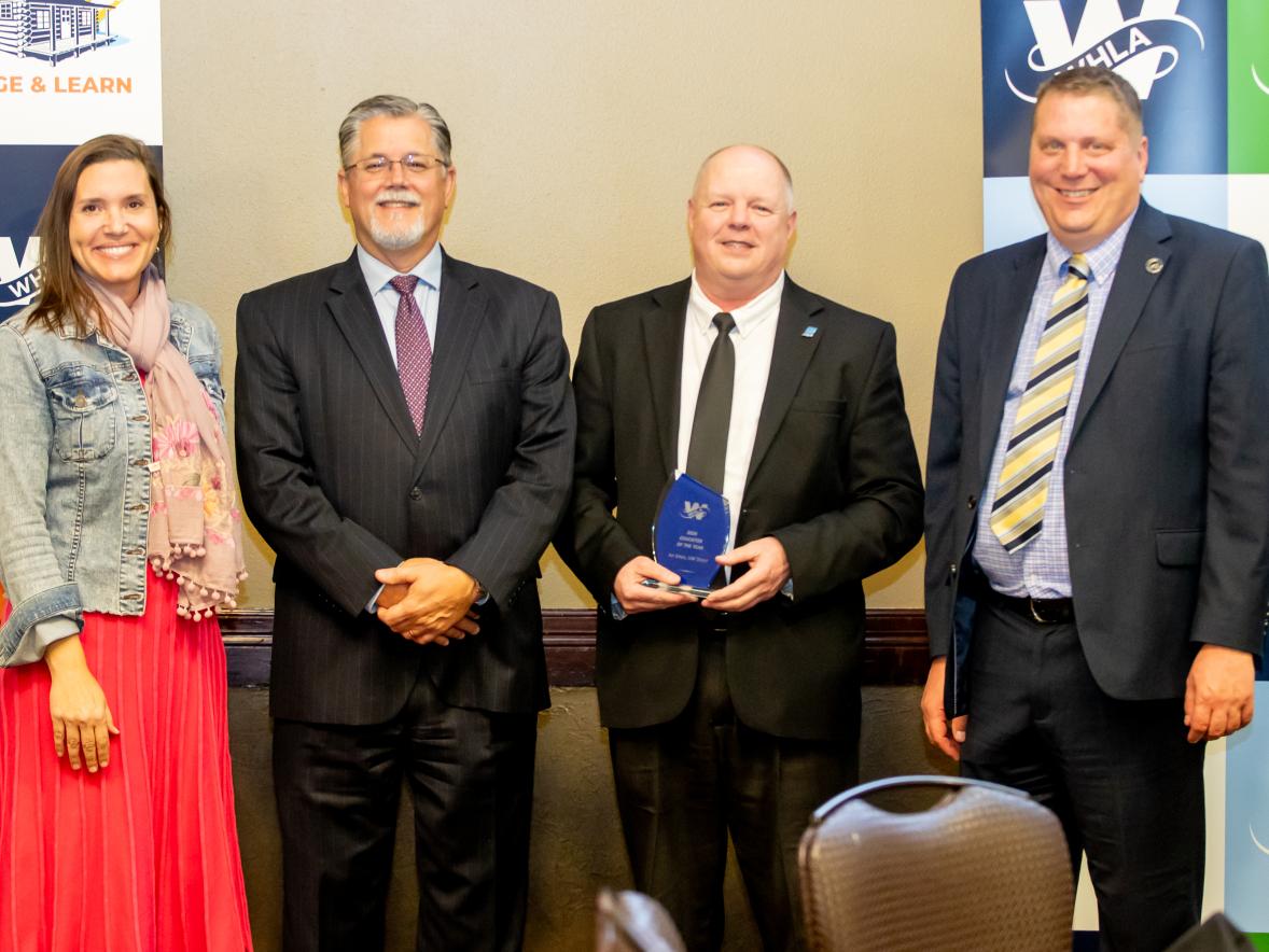 Jay Jones poses with WHLA representatives during Educator of the Year Award reception.