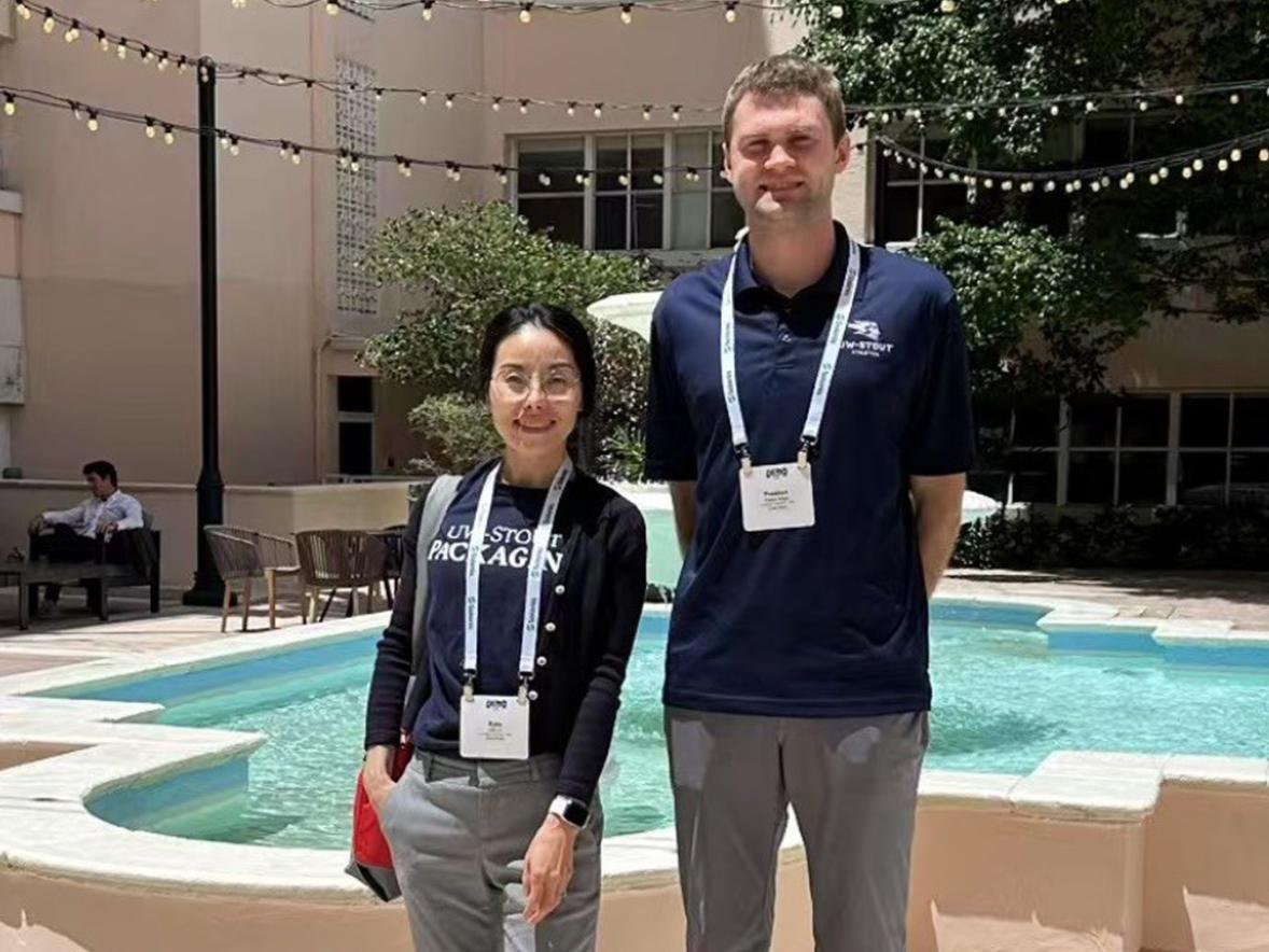 Two people stand in a hotel courtyard in front of a fountain.