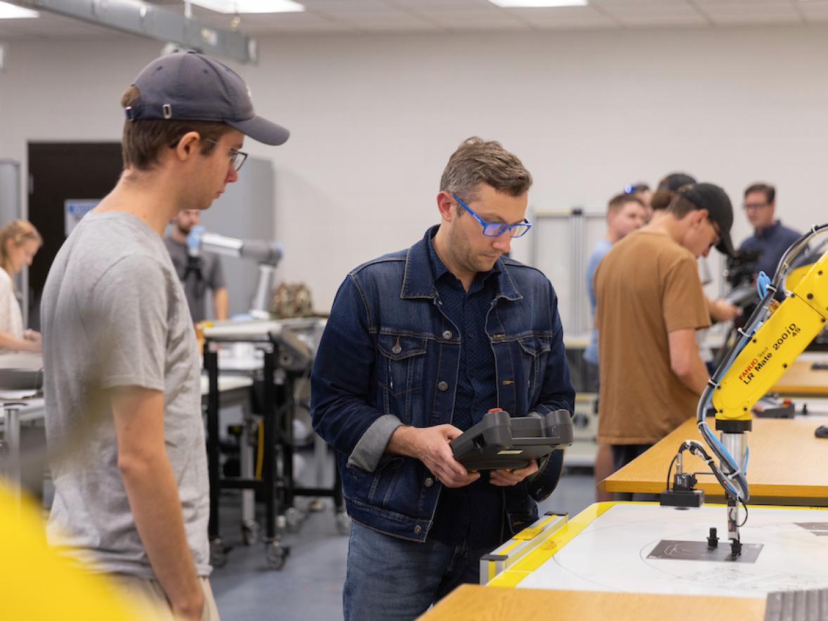 Students program software for robotic arms in an automation lab