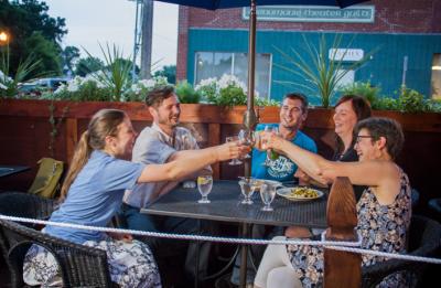A group of friends cheers while enjoying a cold beer at a local restaurant.
