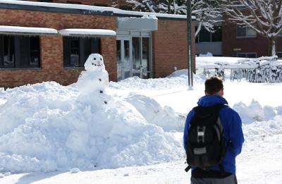 A student walks past a snowman outside McCalmont Hall as campus is covered with a fresh layer of snow Tuesday, January 23, 2018.
