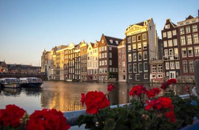 A canal in The Netherlands, with flowers and buildings reflected in the water.