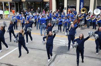 Cheer team and band perform in the Homecoming Parade on Main Street