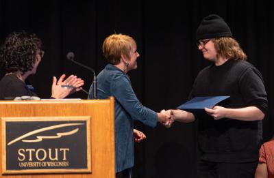 Simon Anderson receiving an outstanding research award from Chancellor Katherine Frank.