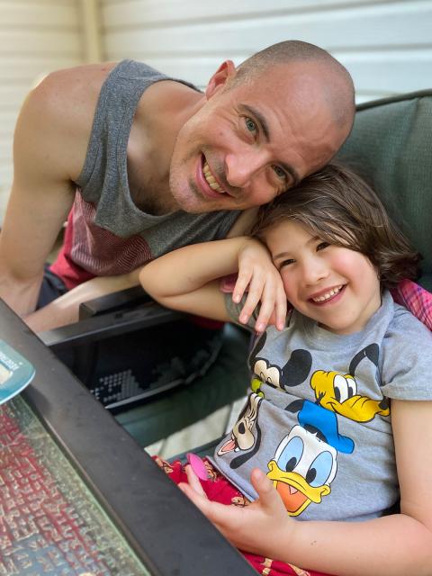 Josh Hellenbrand, management graduate, at home with his son.