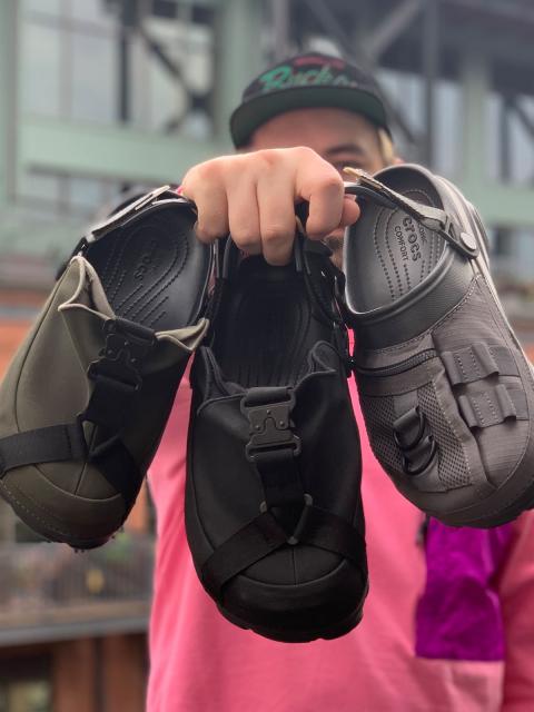 Alexander Mayhew, industrial design graduate, holding three of his BEAMS X Crocs designs.