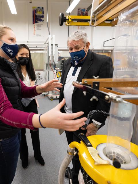 Thompson listens as a student explains a process in the plastics engineering lab.