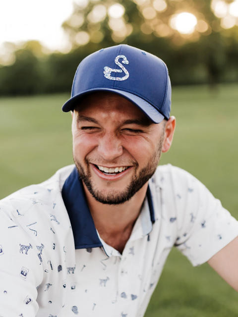 Dylan Zins, a former UW-Stout athlete, models a Swannies Golf shirt and hat.