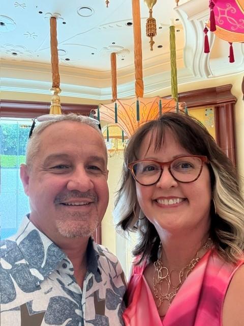 Two people pose together indoors for a selfie-style photo.